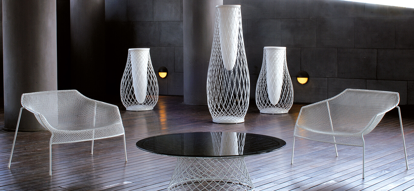 The idea underlying Heaven project is that of lightness derived from forms emerging from hollow spaces bordered by interweaving lines. The thin, woven steel frame is the distinctive feature of a collection marked by well-proportioned lines and overall harmony. Steel chairs paired with transparent glass tops lighten the table surfaces, lending them almost an intangible aspect.